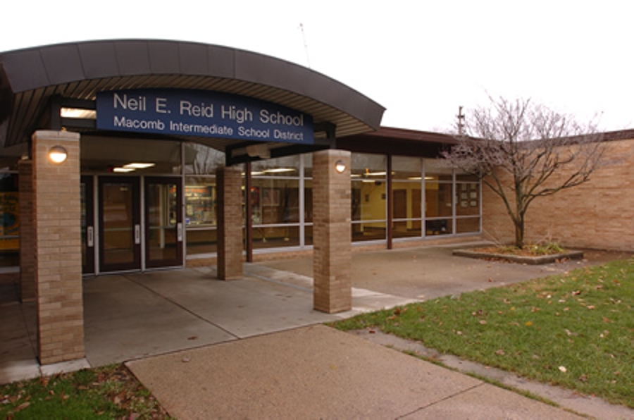 Front view of Neil E. Reid high school building in the fall with scattered leaves on the ground.